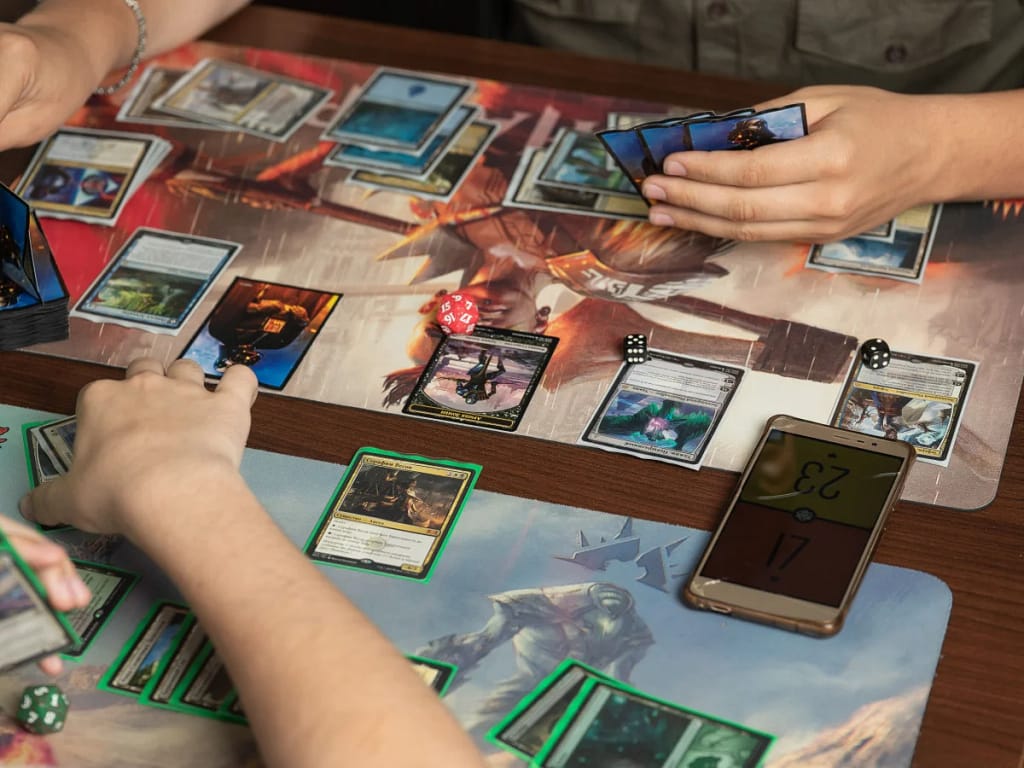 2 players playing a game of Magic: the Gathering, camera angle is from one person's side of the table