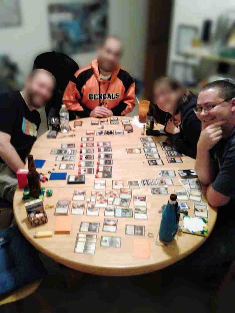 Friday Night Magic with friends circa 2011. Bryan on the right with 3 friends around a table covered with Magic cards, dice, and drinks.