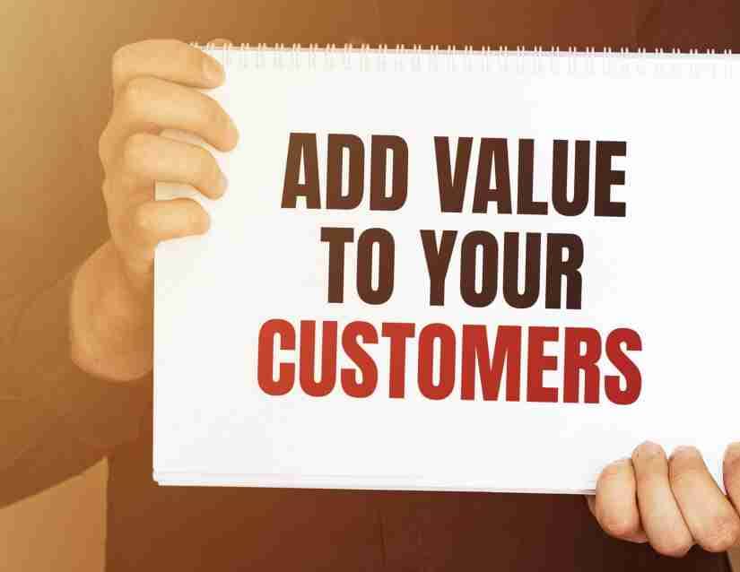a person holding a sign that says "Add value to your customers."