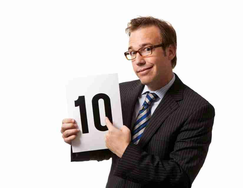 A man in a suit holding a sign that says "10"