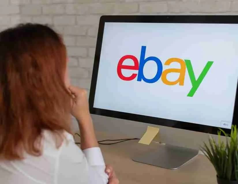 Woman looking at computer monitor with ebay logo, a good place to sell magic cards
